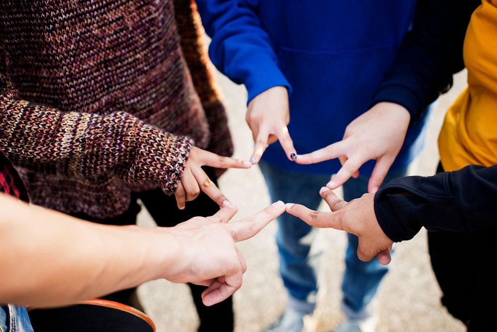 Group of friends using fingers to form the star shape