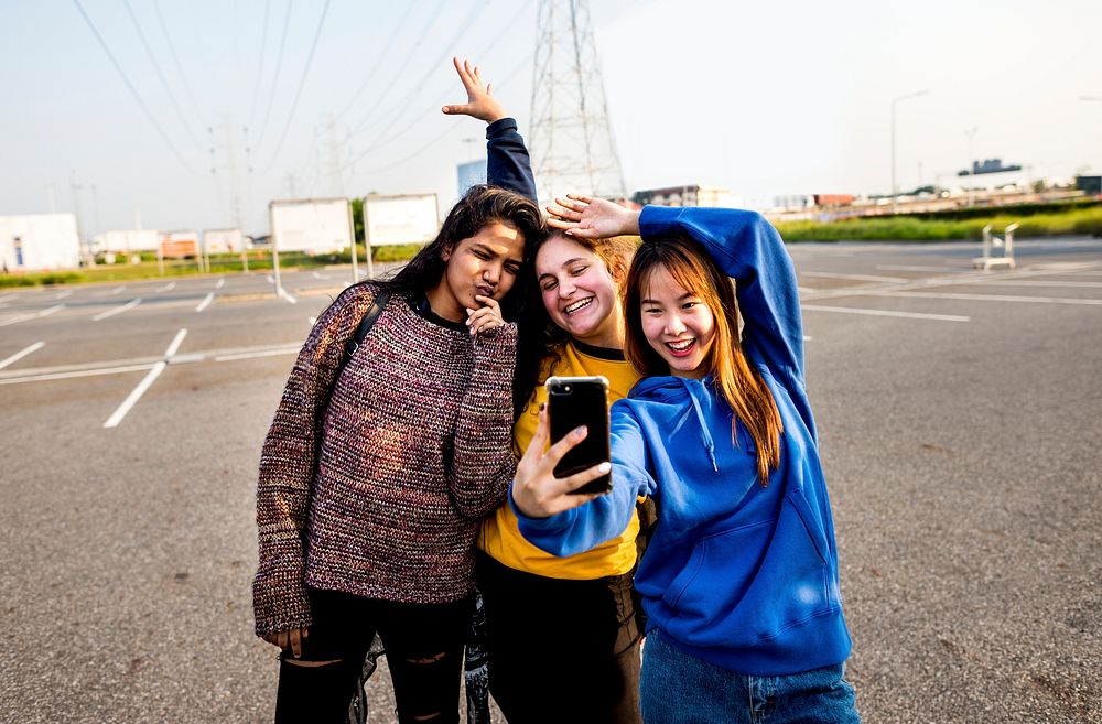 Girl friends smiling and taking a selfie together