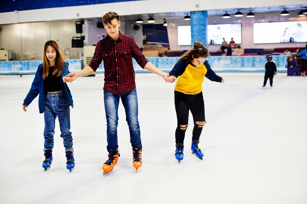 Group of teenage friends ice skating on an ice rink