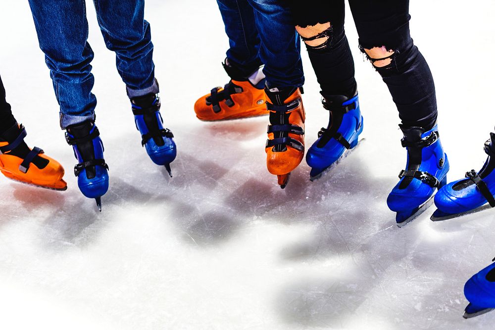 Feet closeup of group of friends ice skating together