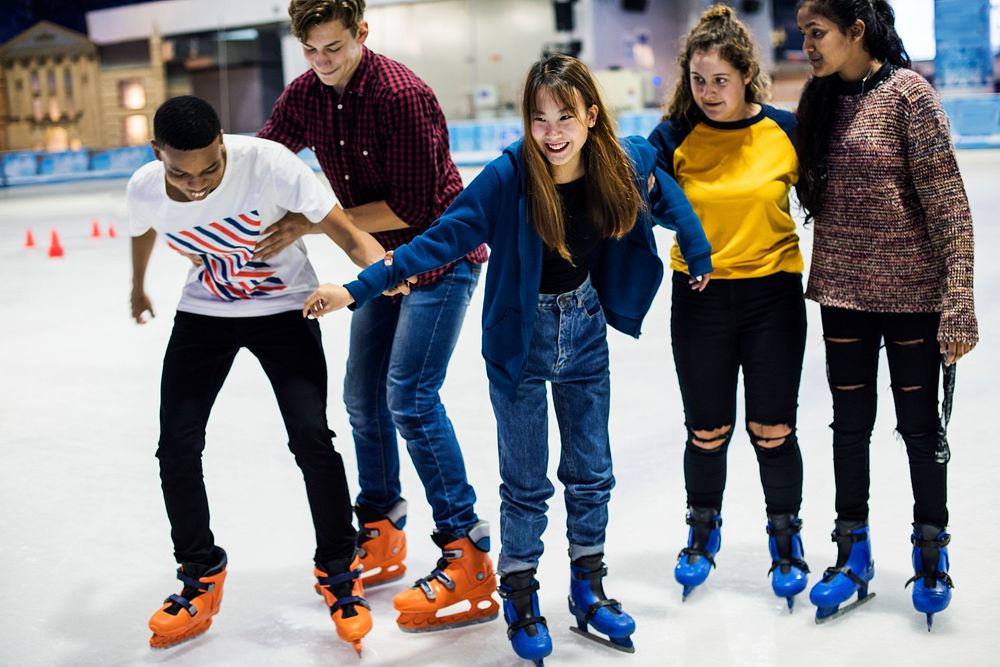 Group of teenage friends ice skating on an ice rink