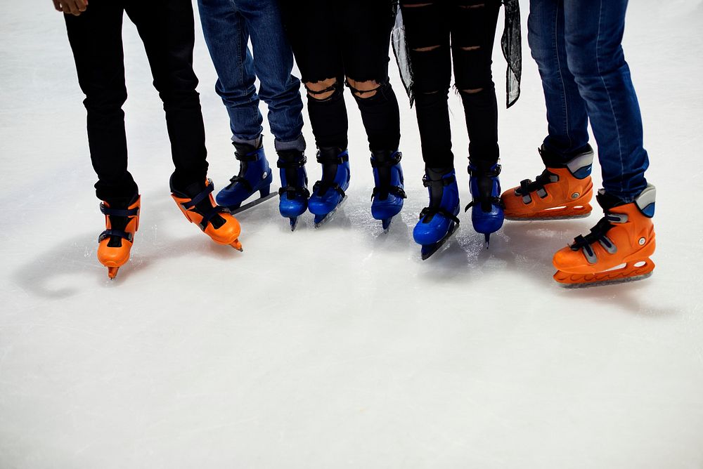 Feet closeup of group of friends ice skating together