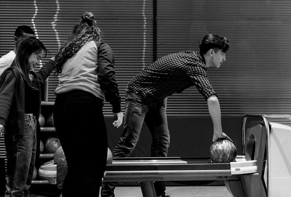 Boy picking up the red bowling ball