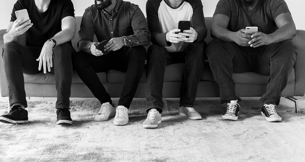 Group of diverse men using mobile phone social media and internet concept