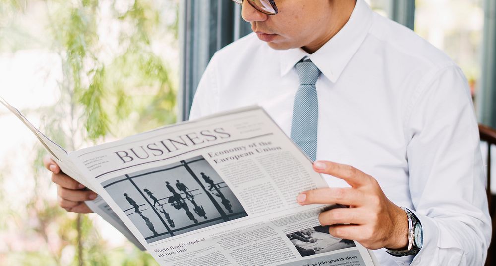 Businessman reading newspaper in the morning
