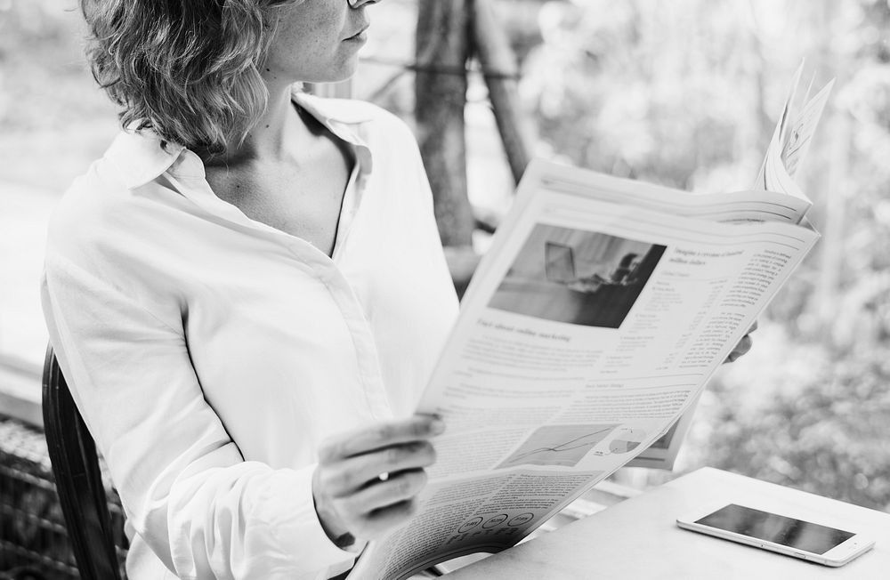 Business woman reading newspaper in the morning