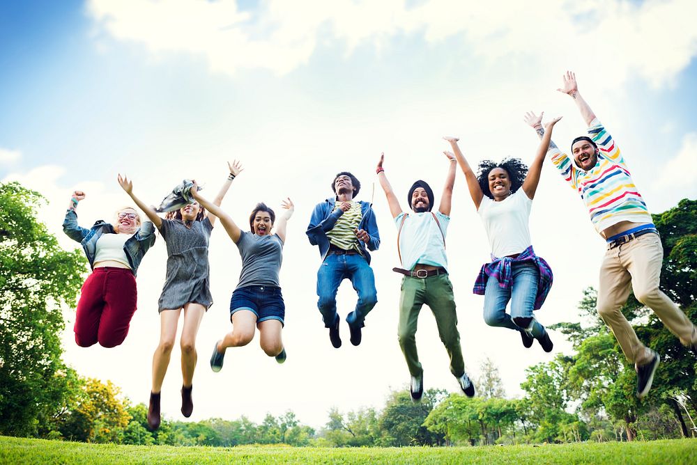 Jump shot of happy diverse friends outdoors