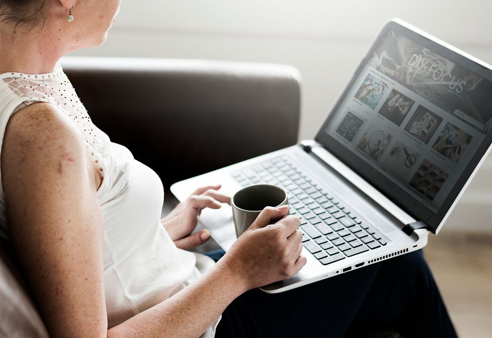 White woman using laptop at sofa