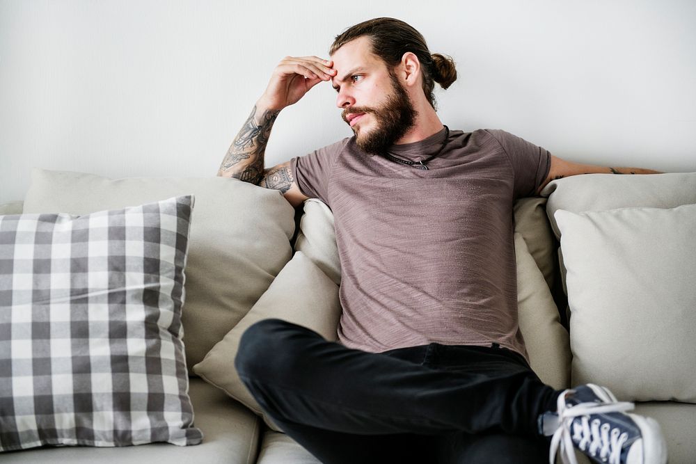 Man with tattoo sitting on a couch