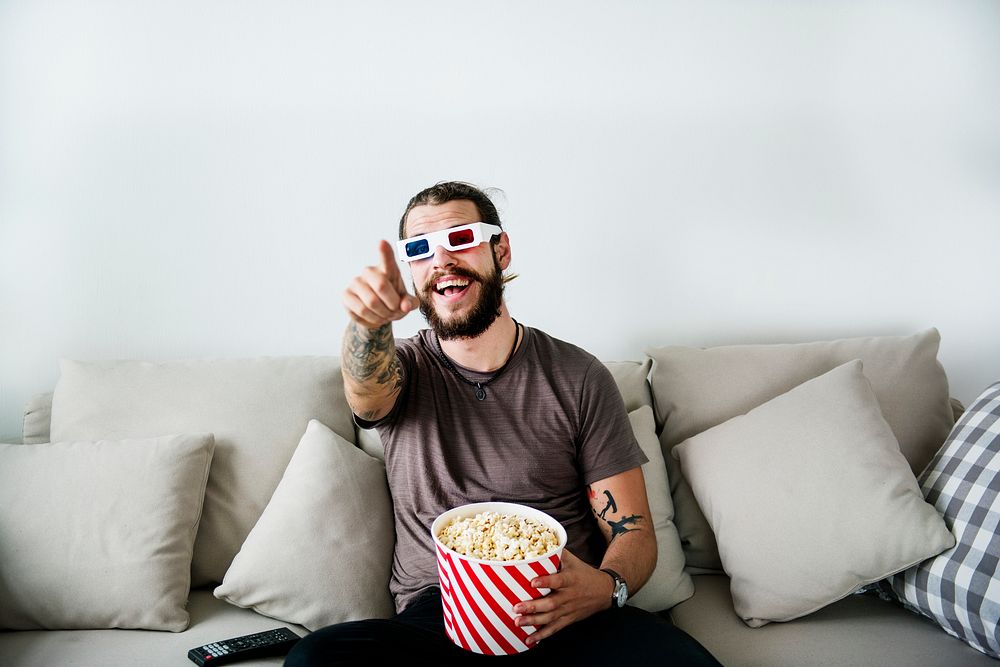 Man watching movie while holding a bucket of popcorn