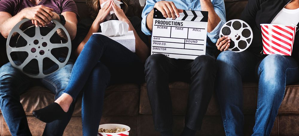 Group of friends holding movie and film objects
