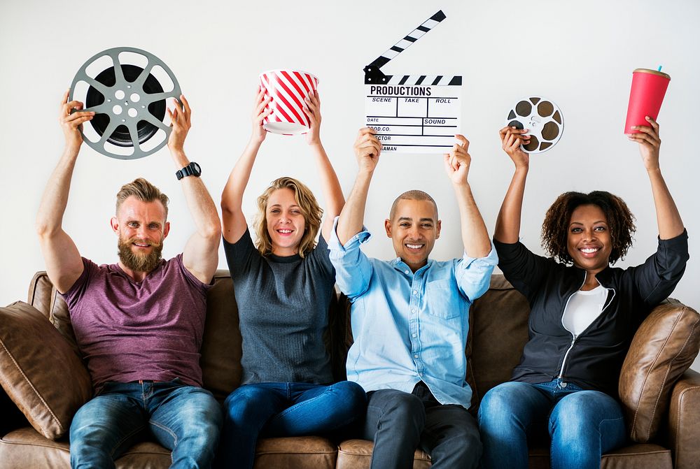 Group of friends holding movie and film objects