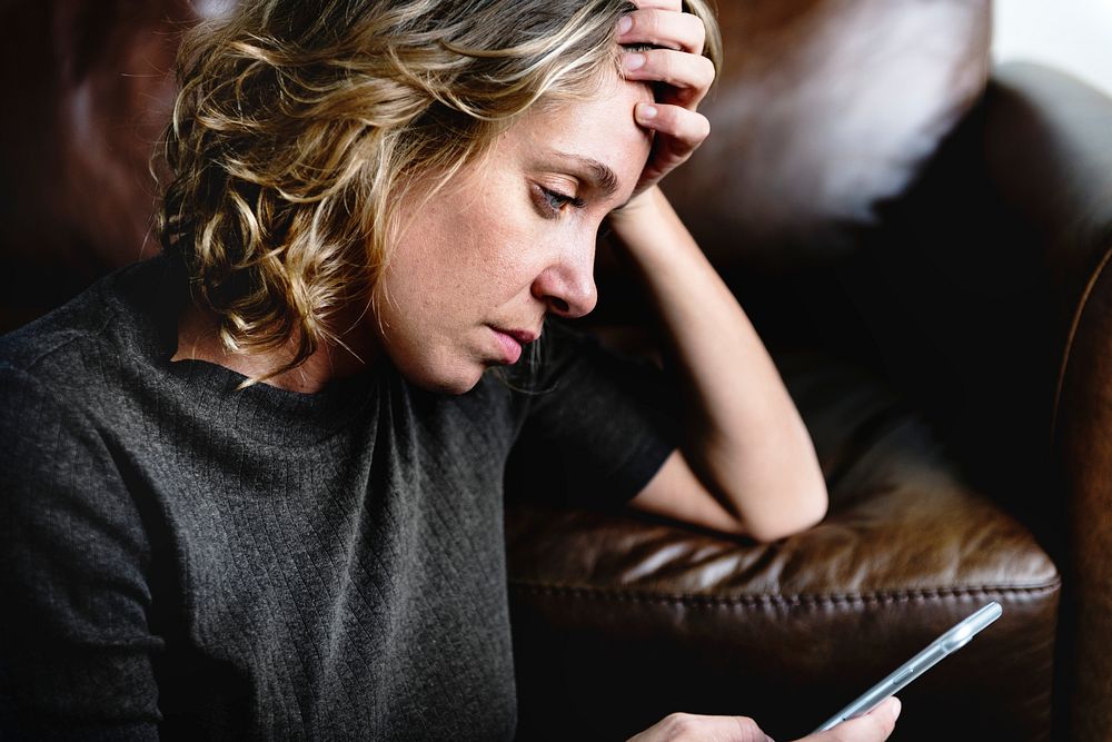 Depressed woman using a mobile phone