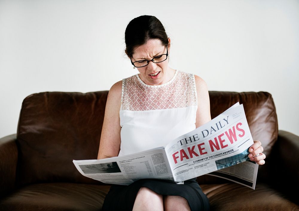 Horrified businesswoman reading fake news