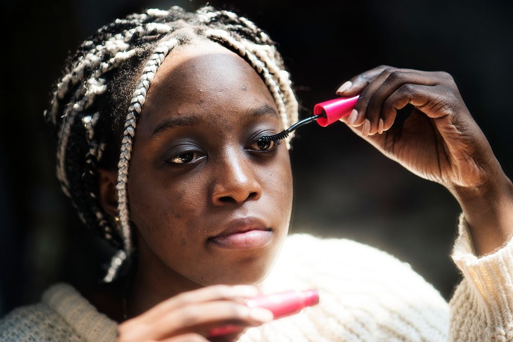 Black woman applying mascara