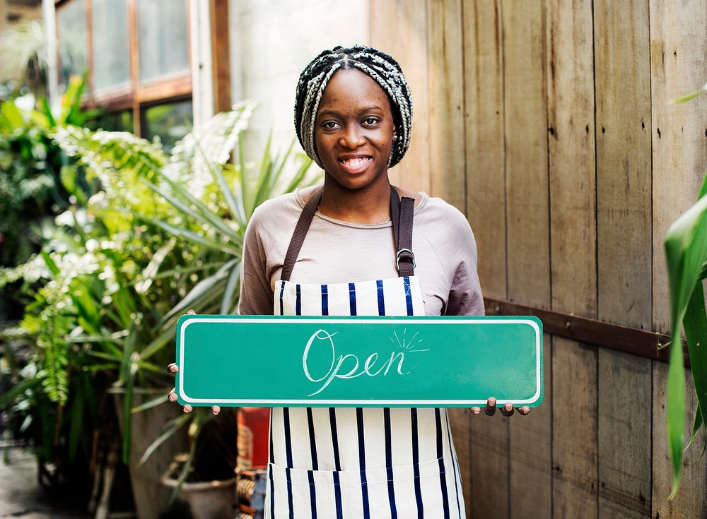 A person holding an "open" sign