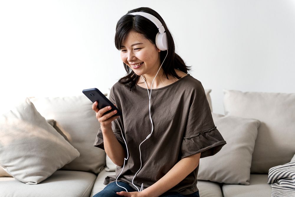 Asian woman enjoying music at home