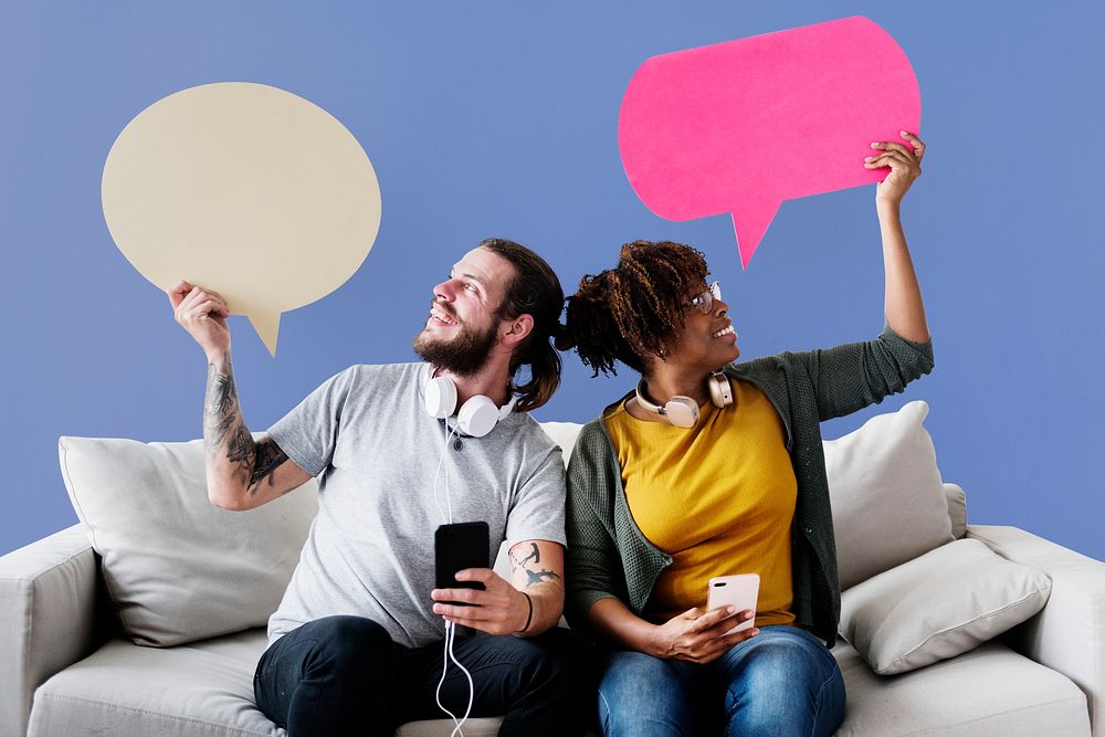 Cheerful couple holding speech bubble icons