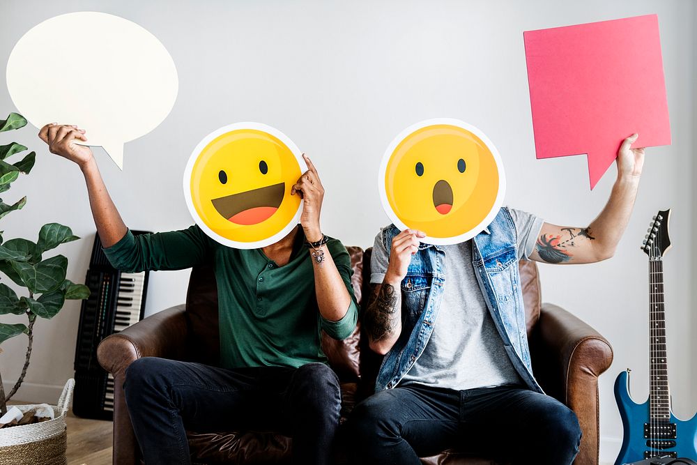 Friends holding an expressive emoticon faces and speech bubbles