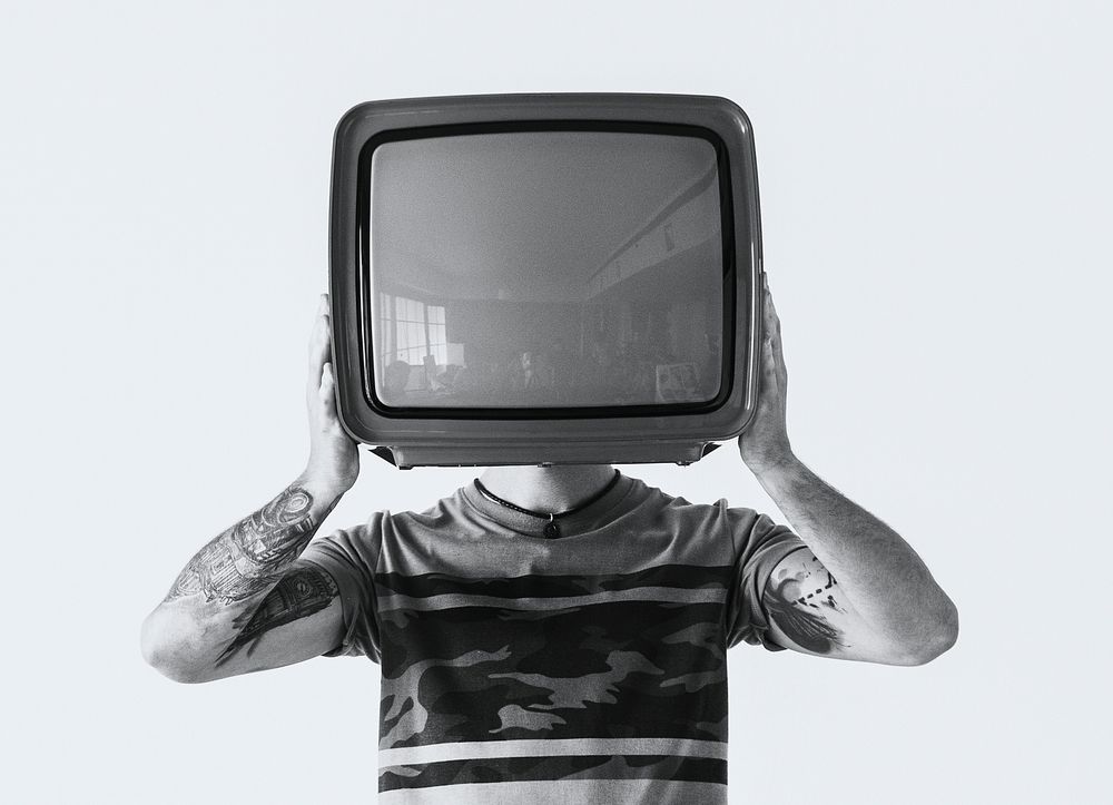 Person with tattoo holding television