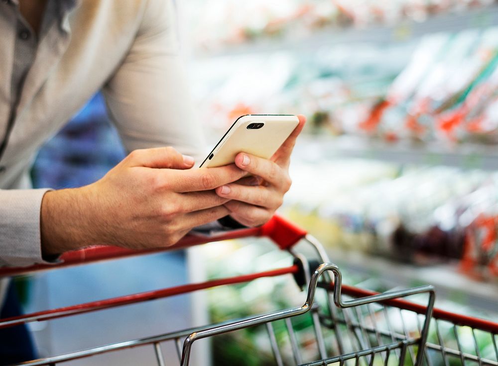 Man playing with his phone at supermarket