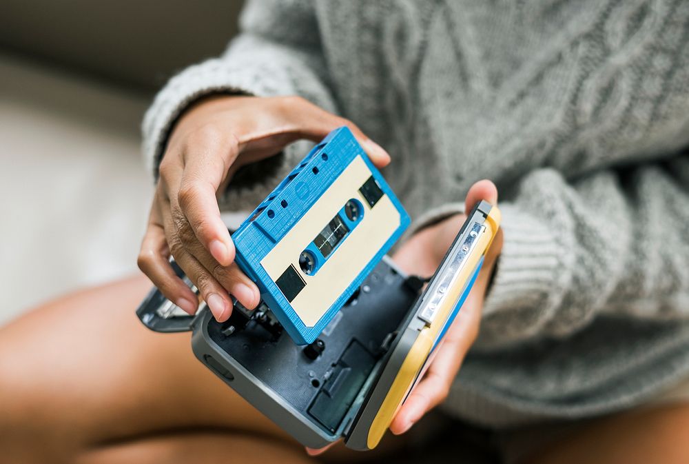 Woman putting a cassette in a cassette player