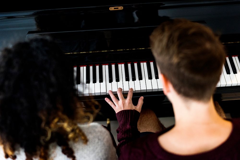 Couple praticing on a piano together