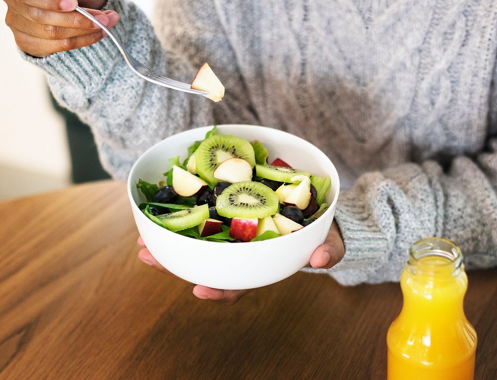 Woman holding a bowl of healthy mixed salad
