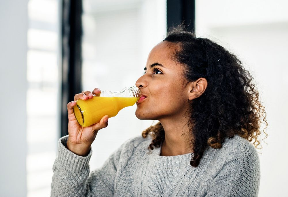 Woman drinking fresh orange juice Premium Photo rawpixel