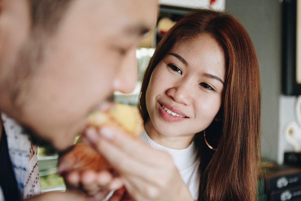 Asian girl feeding her boyfriend
