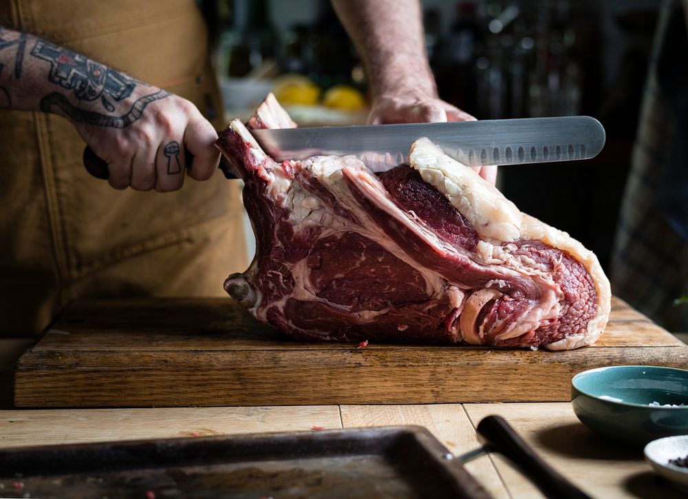 Butcher cutting a tomahawk steak