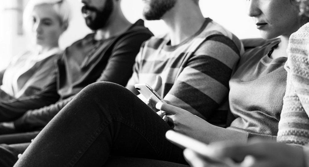 Group of people using mobile phone on couch