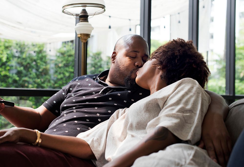 Black couple kissing on the couch