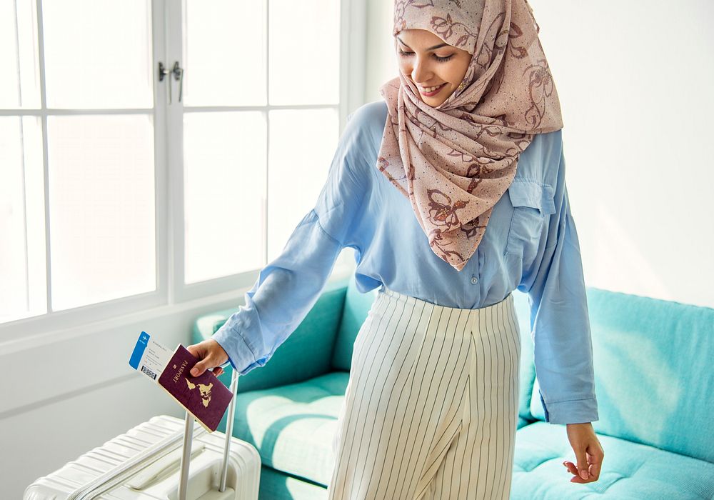 Muslim girl holding a passport and a flight ticket