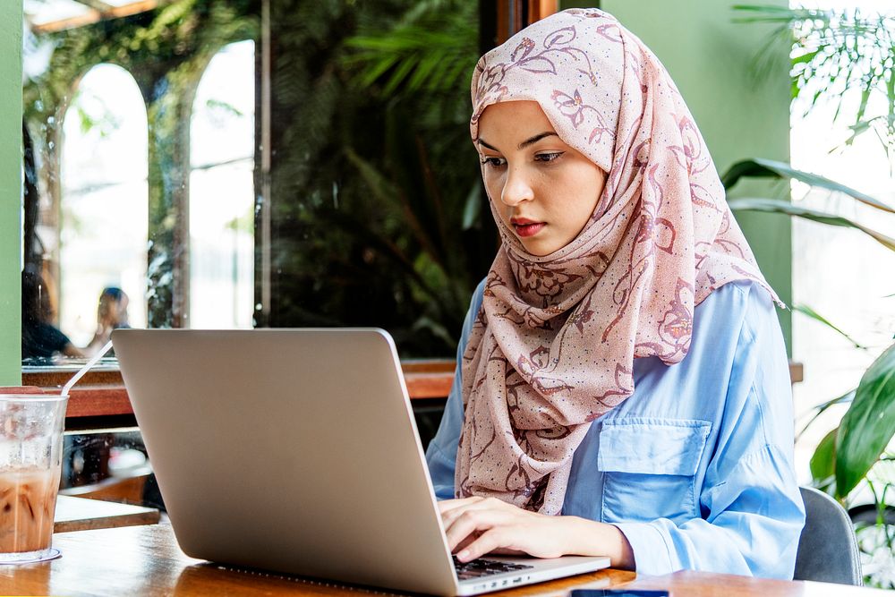 Islamic woman sitting and using laptop