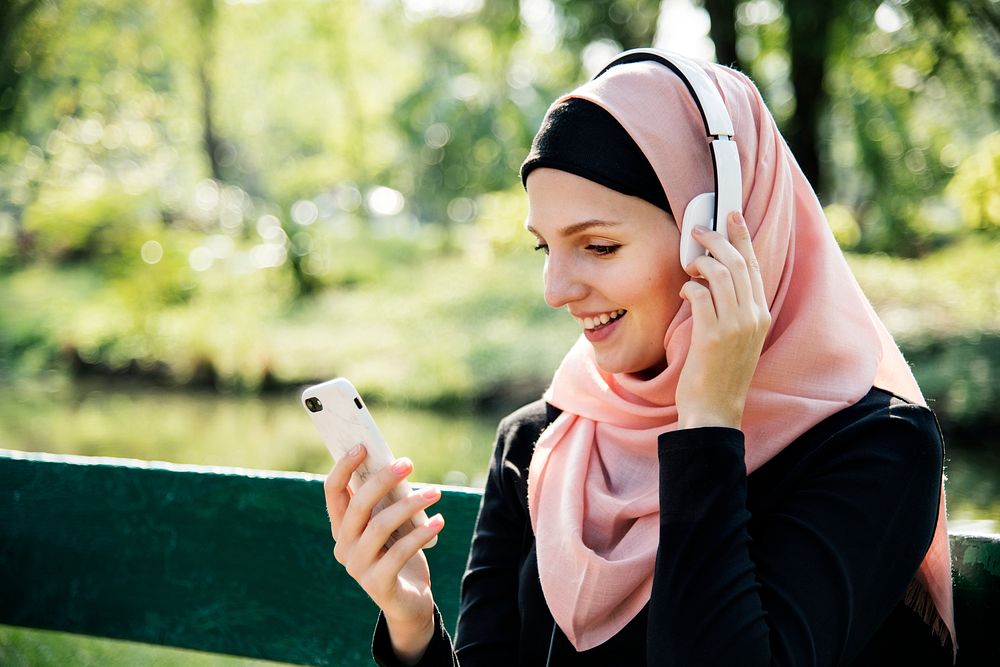 Islamic woman using mobile phone to listening music
