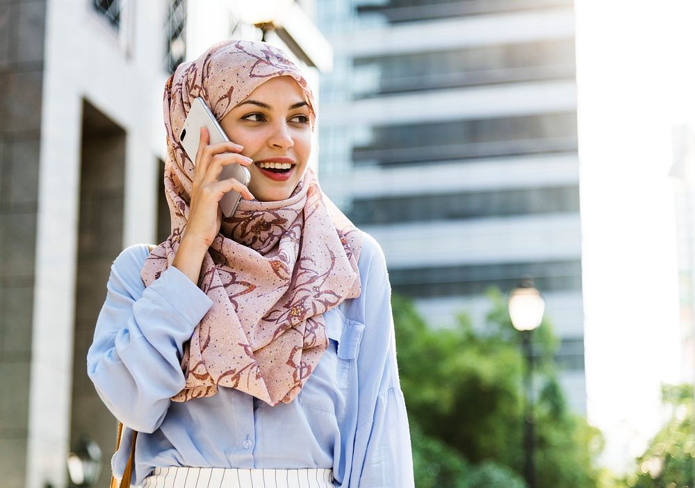 Islamic woman using mobile phone with smiling