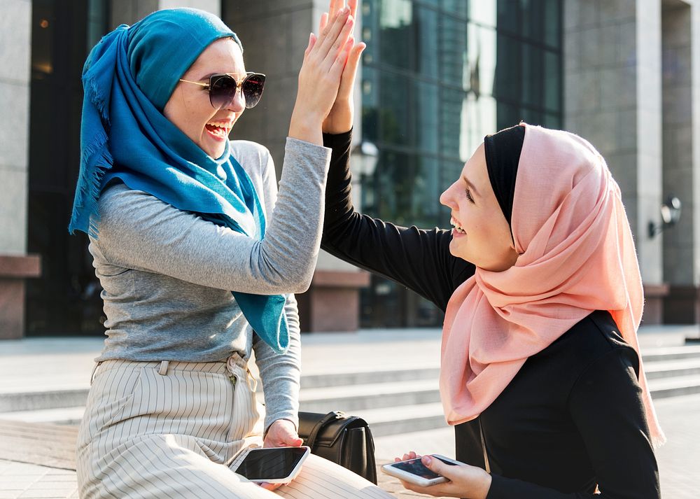 Islamic friends high five and smiling