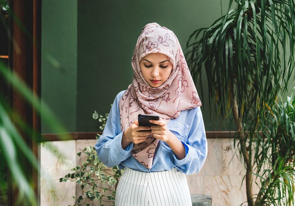 Muslim woman texting on her smartphone