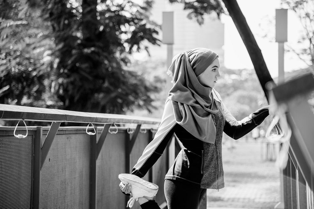 Islamic woman stretching after workout at the park