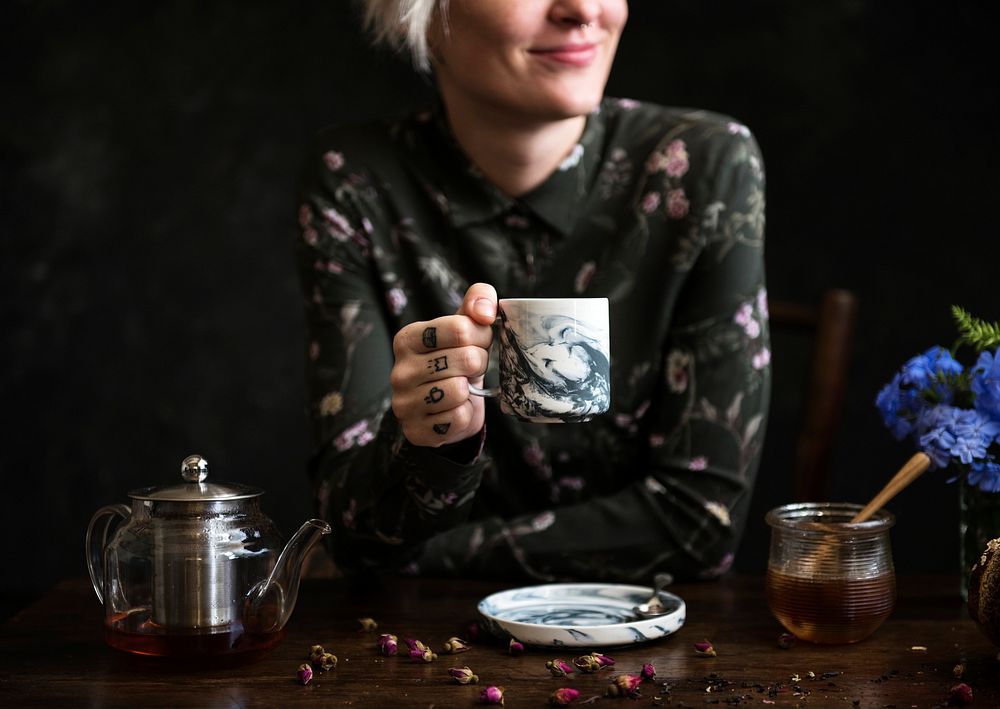 Tattooed woman having a cup of tea