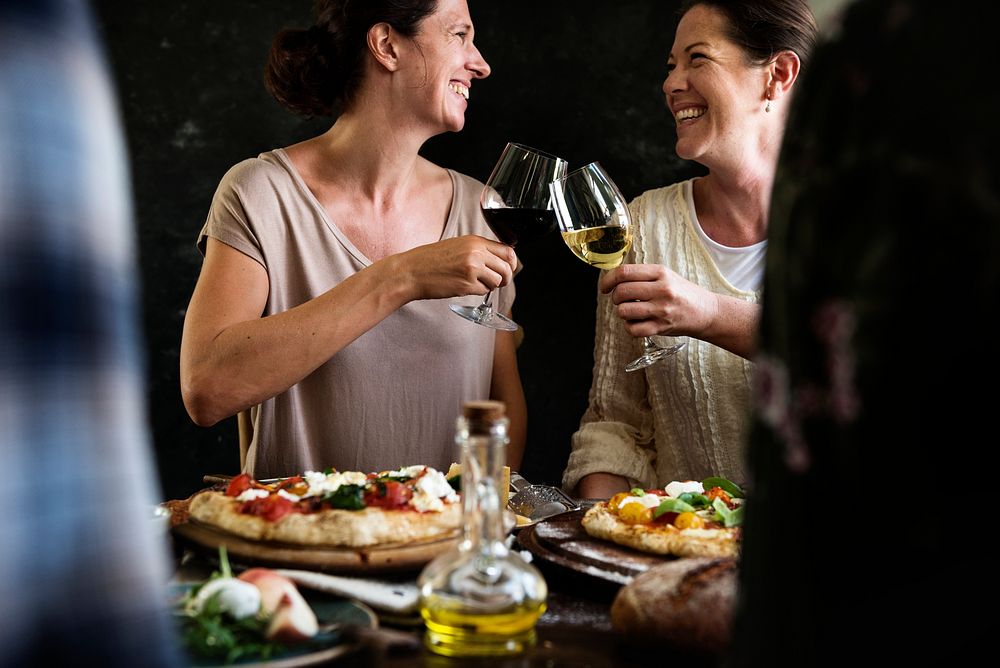 Happy women cheering with glasses of wine