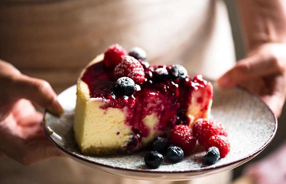 Slice of cheesecake topped with mixed berries sauce