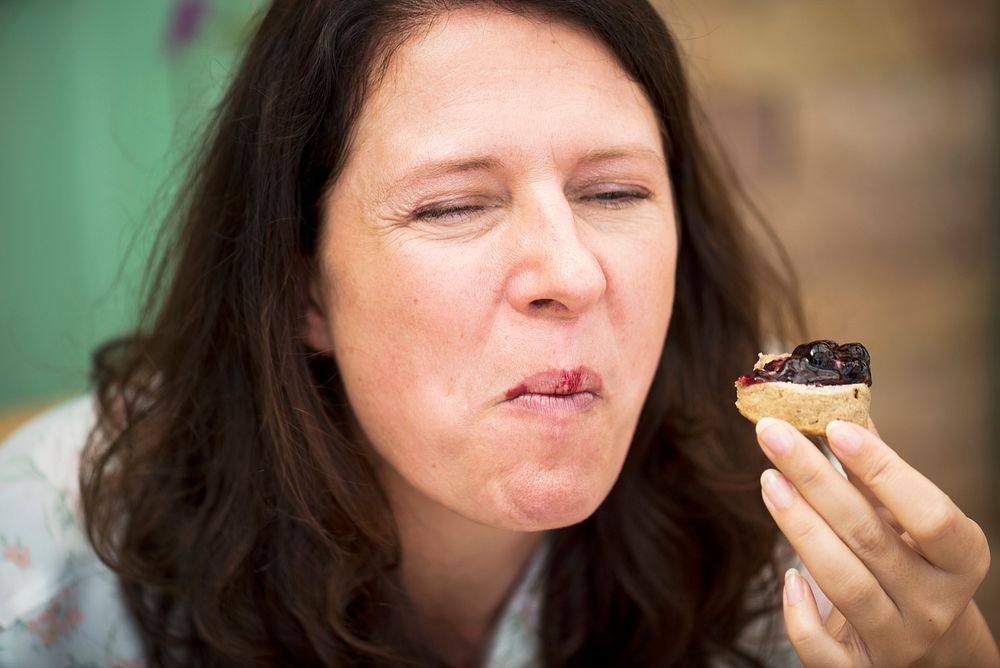 Woman eating scones with raspberry jam