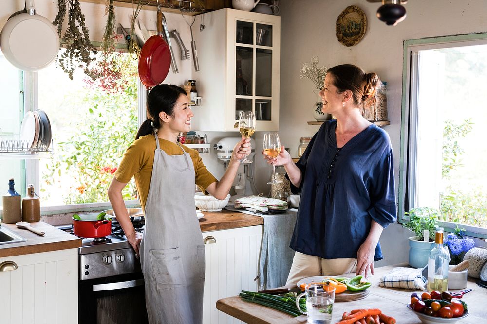 Women having a glass of white wine in the kitchen