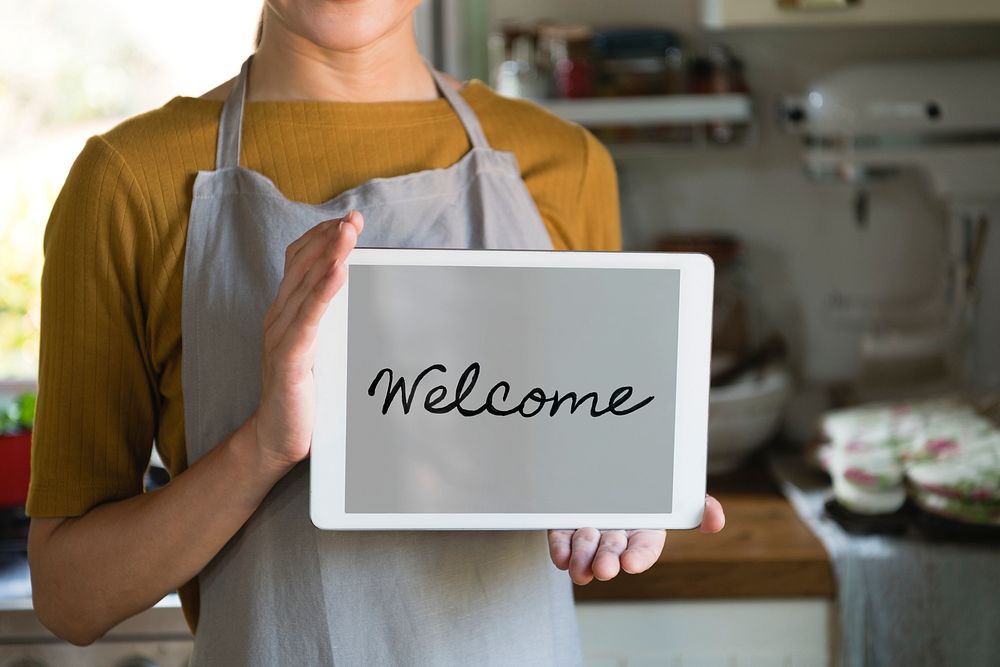 Woman holding a screen with the word welcome