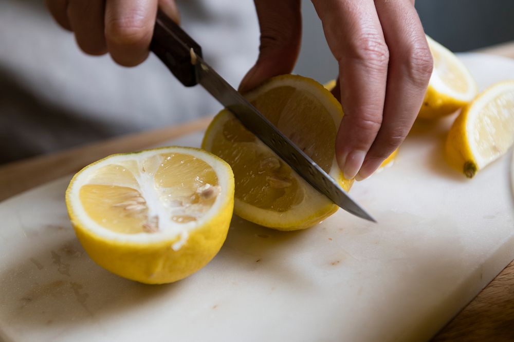 Cook cutting fresh yellow lemon