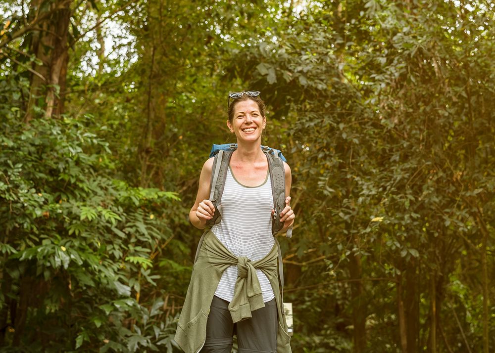 Cheerful female backpacker in the forest