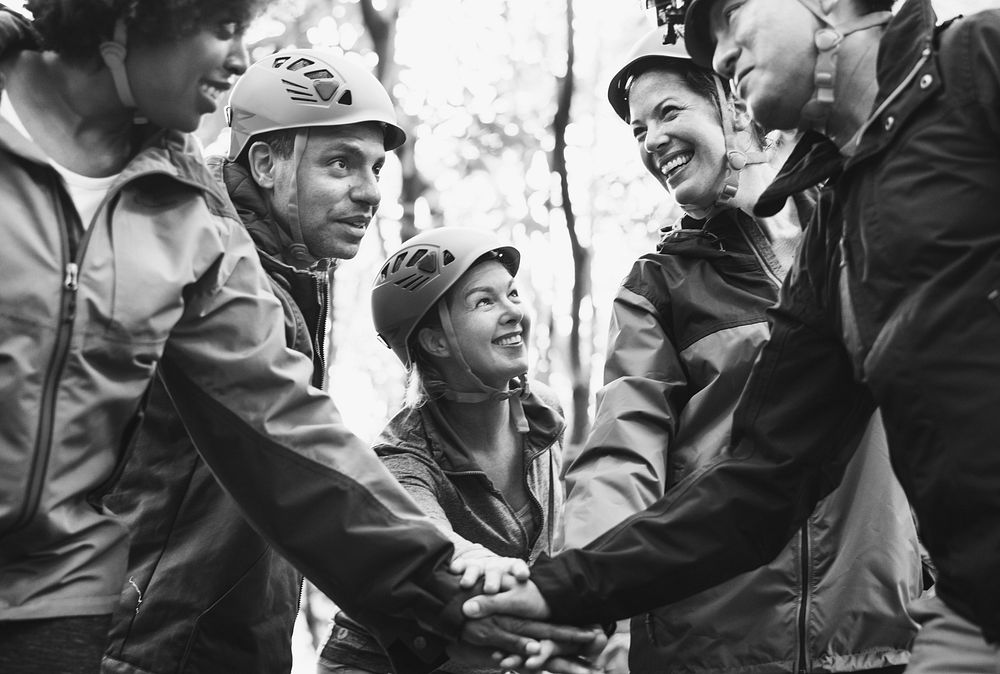 Team of diverse hikers stacking hands together