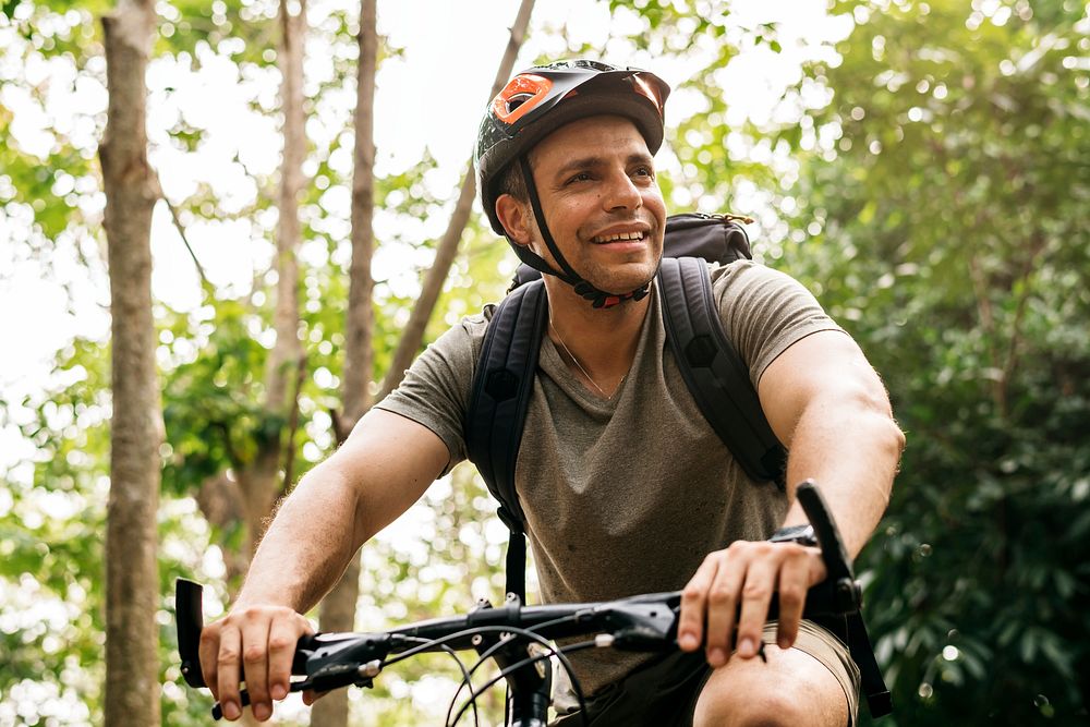 Happy cyclist riding through the forest